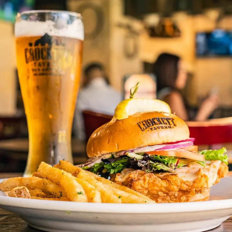 Crockett Tavern branded fried sandwich, fries, and amber beer.