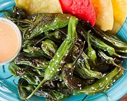 Blistered green peppers with sesame seeds and orange dipping sauce.