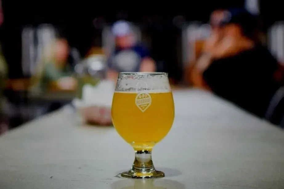 Frothy beer in a stemmed glass with Roadmap Brewing Co. logo.