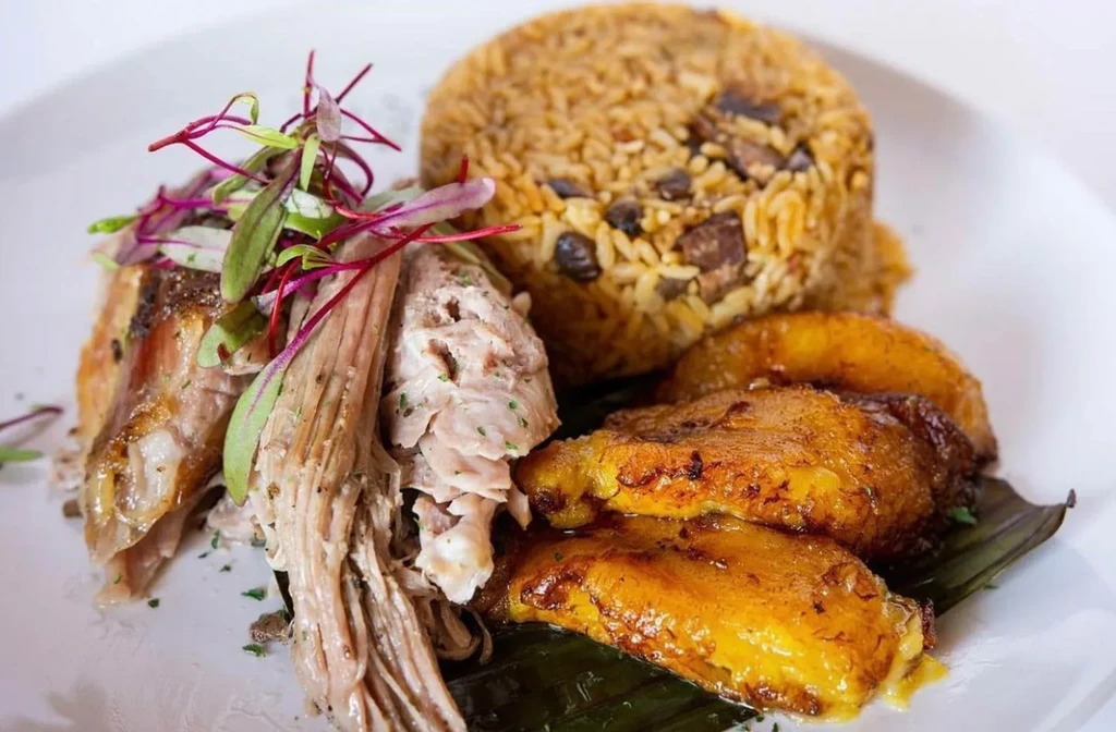 Pulled pork, rice and beans, and sweet plantains, well-plated.