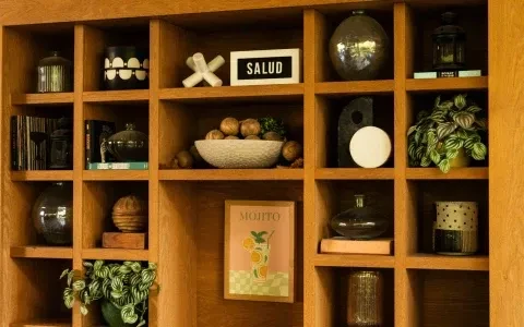 Light wood shelving unit filled with vases, books, and decorative objects.