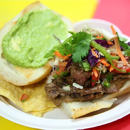 Colorful open-faced steak sandwich, pico de gallo, guacamole, and tortilla chips.