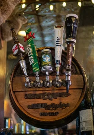 Five beer tap handles mounted on a wooden half-barrel, "MICHELOB ULTRA ON TAP."