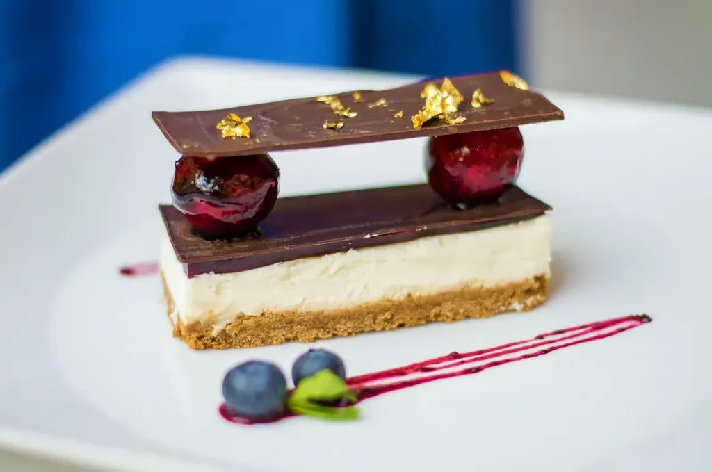 Elegant layered dessert bar with chocolate, glazed fruit, and gold leaf.