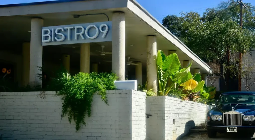 Modern Bistro 9 exterior, white brick, lush plants, classic car.
