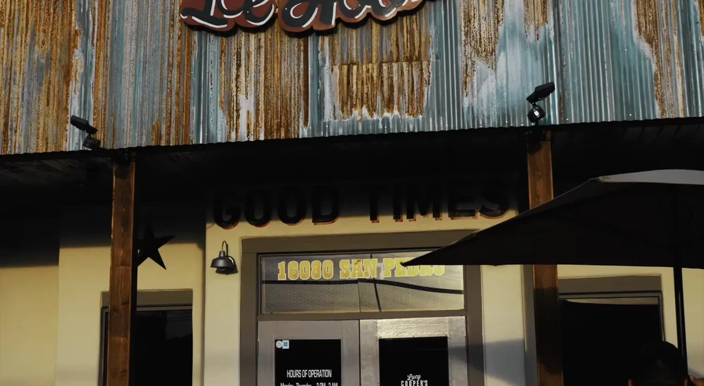 Dark 'GOOD TIMES' bar facade with heavily rusted corrugated metal siding.