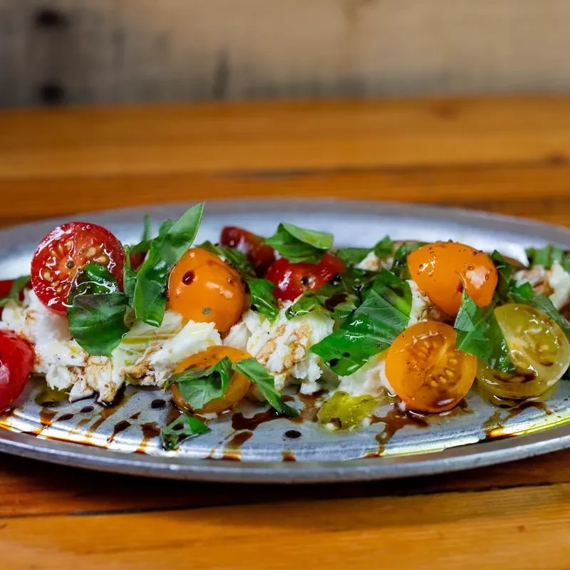 Fresh heirloom tomato, mozzarella, and basil salad drizzled with balsamic.