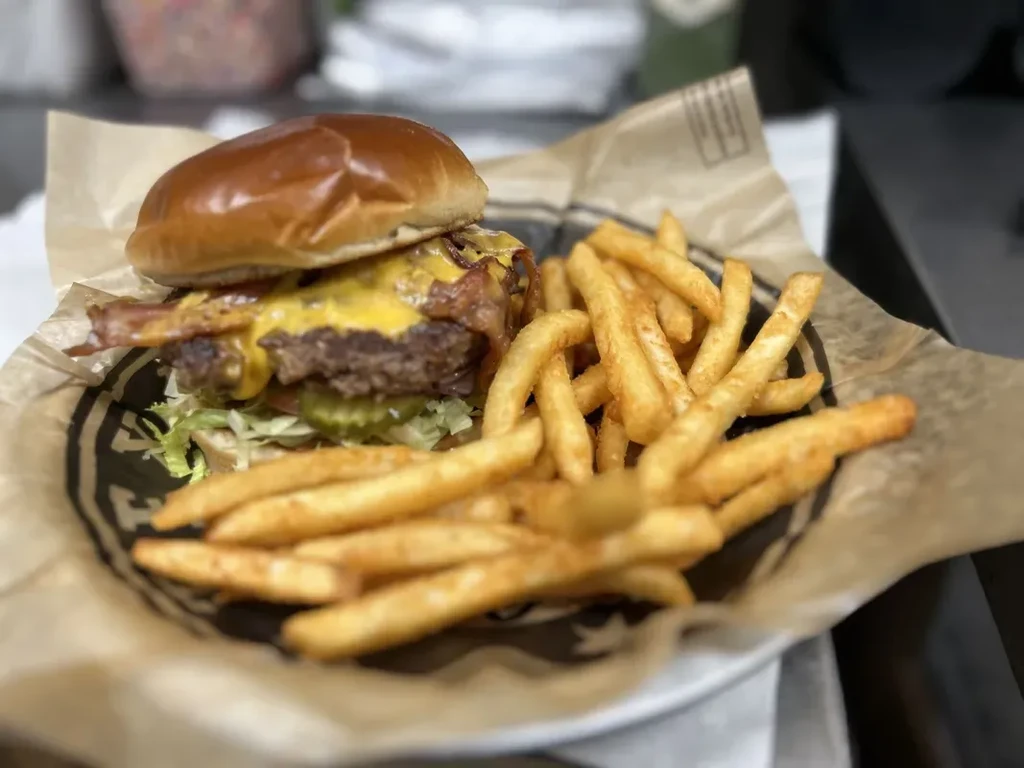 Cheeseburger with bacon and golden fries in a casual basket.