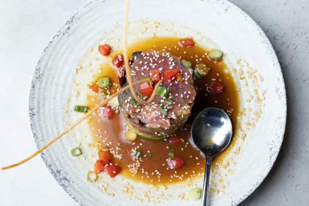 Finely diced tuna stack with avocado, sesame, and amber sauce.