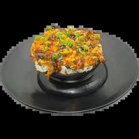 Vibrant rice bowl with diverse toppings, glistening sauce, in dark bowl.