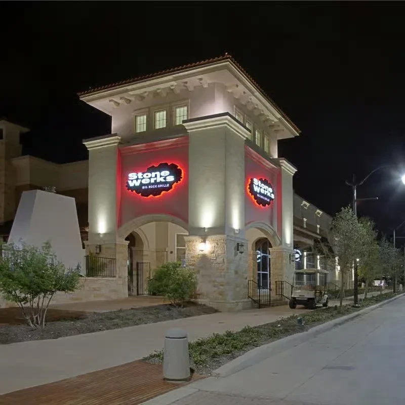 Exterior of Stone Werks Big Rock Grille restaurant at night, lit by neon.