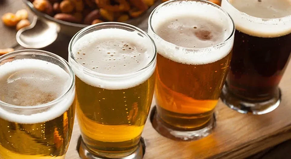A beer flight with four glasses ranging from light to dark.