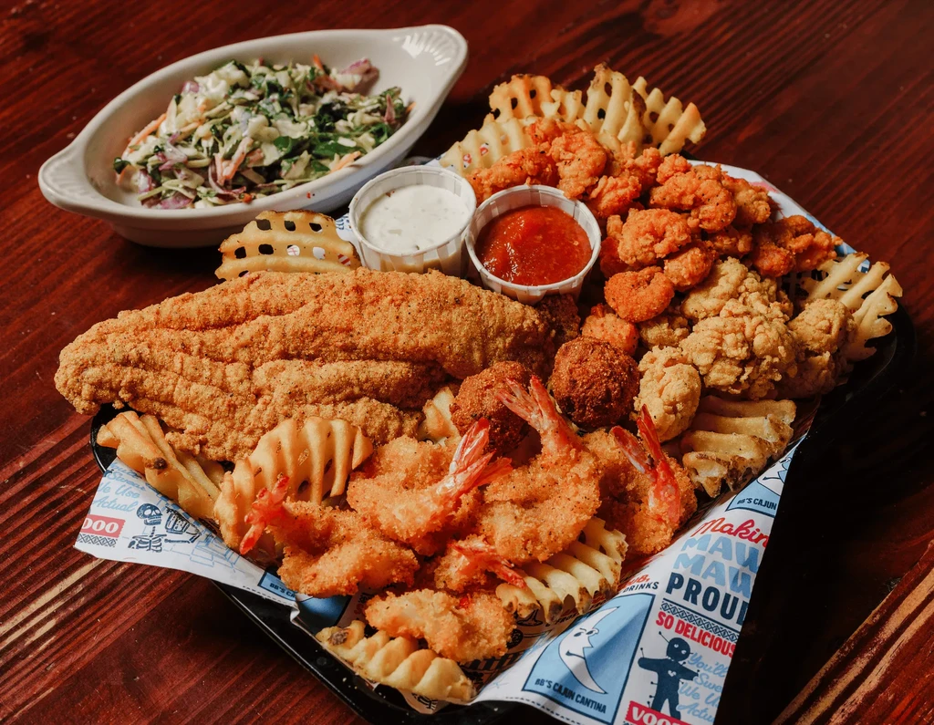 Fried seafood platter with catfish, shrimp, oysters, hushpuppies, and waffle fries.
