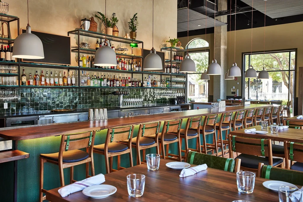 Wide view of an empty, modern restaurant bar and dining area.