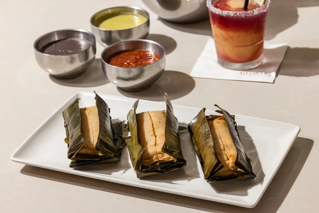 Three tamales in banana leaves, three dips, and a cocktail at Gloria's.