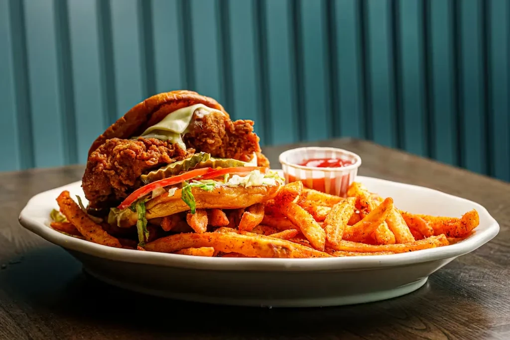 Hearty fried chicken sandwich with seasoned fries and ketchup.