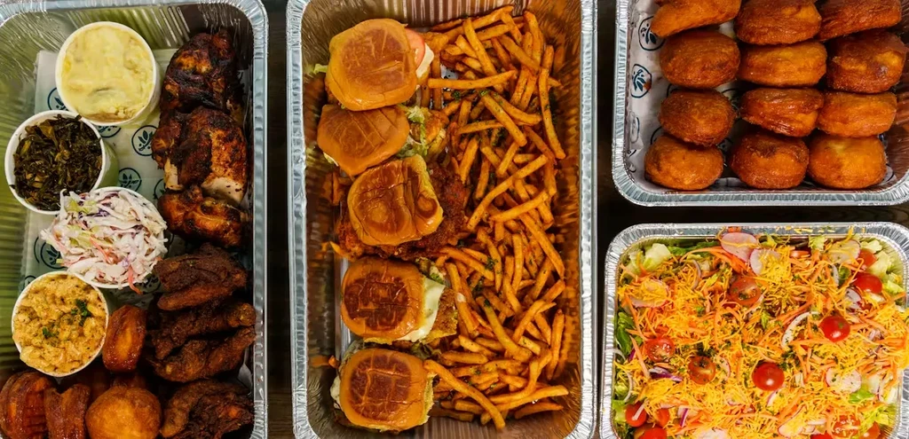Four takeout containers with fried chicken, sides, salad, and fried dough.
