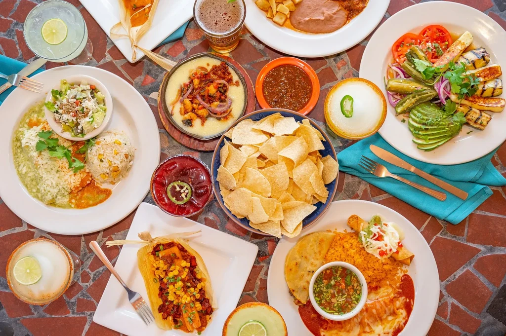 Overhead view of a vibrant Mexican and Tex-Mex food and drink spread.