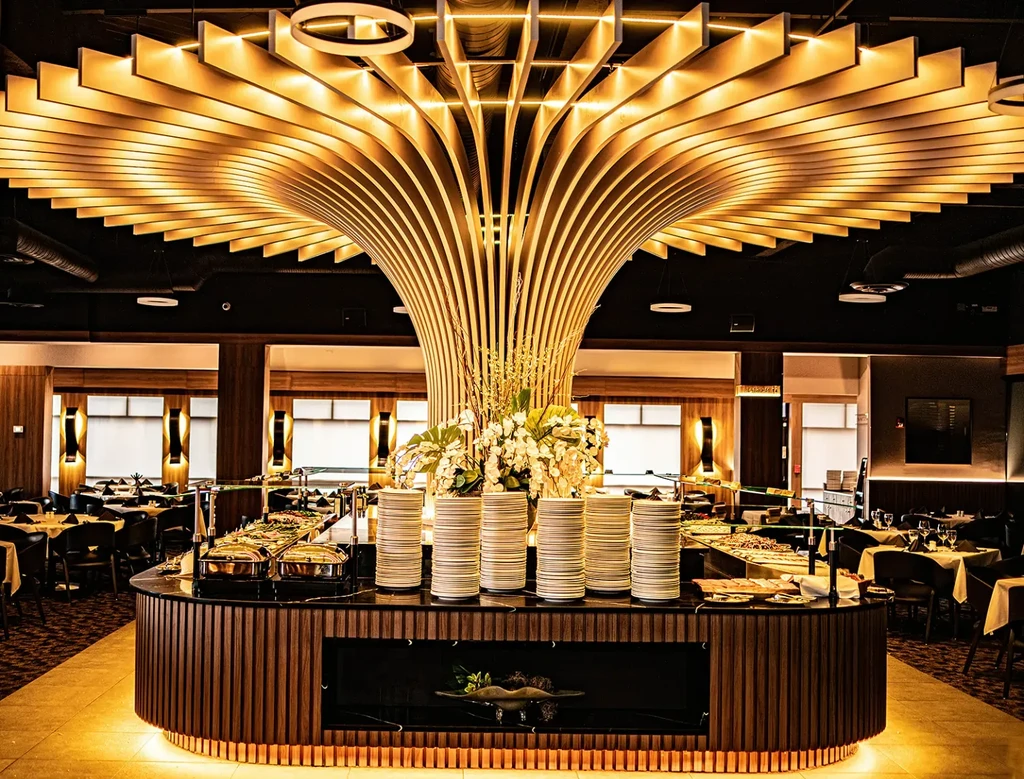 Luxurious restaurant buffet under a golden wave-like ceiling.