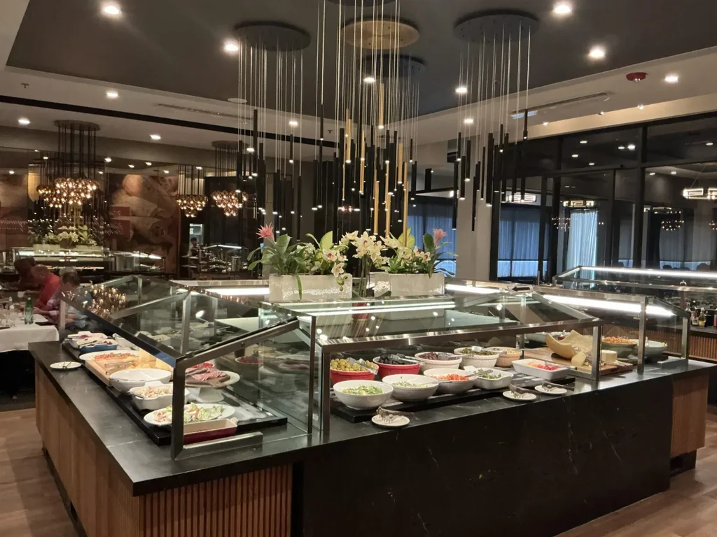 Upscale restaurant interior with a large, well-stocked food buffet.