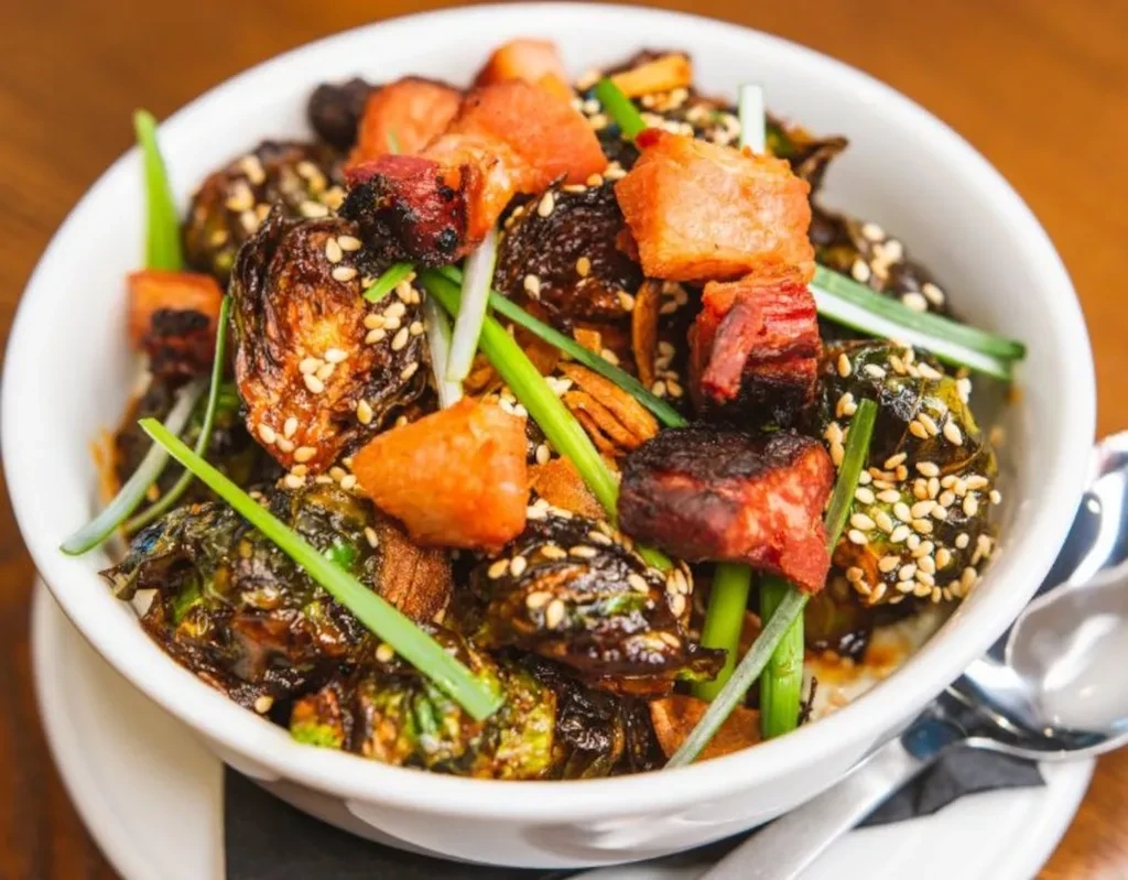 Caramelized Brussels sprouts and crispy pork belly with sesame and scallions.