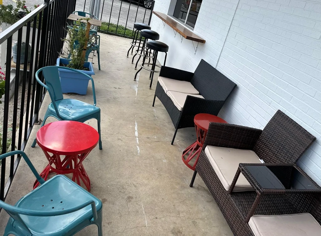 Restaurant patio with varied outdoor furniture: metal chairs, wicker seating, bar.
