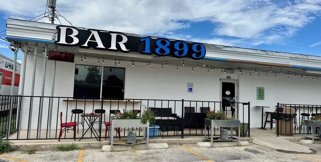BAR 1899, a white brick bar with an outdoor patio.