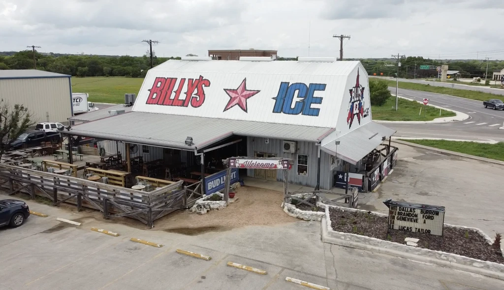 Elevated view of rustic Billy's Ice building with colorful roof sign.