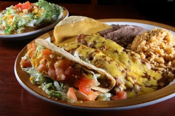 Plate of Mexican food: enchiladas, taco, beans, rice, and tostada.