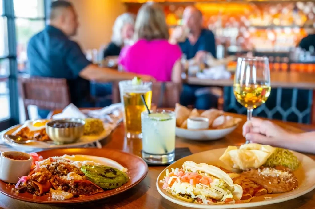 Three plates of food and drinks on a restaurant table.