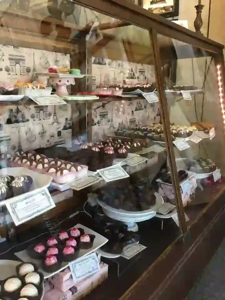 Parisian display case stocked with chocolates, truffles, cupcakes, and macarons.