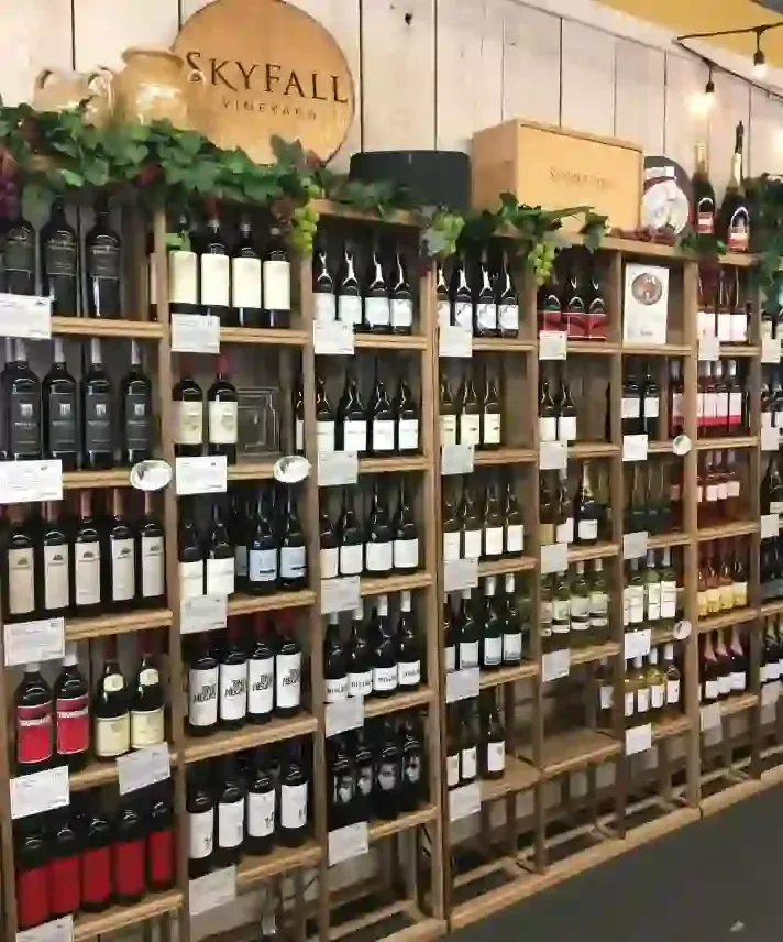 Skyfall Vineyards wine bottles on rustic wooden shelves with garlands.