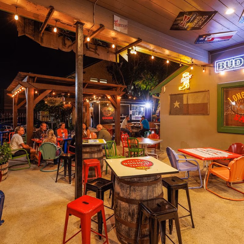 People dining outdoors at a restaurant or bar at night.