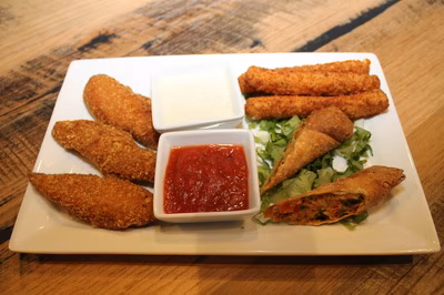 Fried chicken tenders, mozzarella sticks, egg rolls, and dipping sauces.