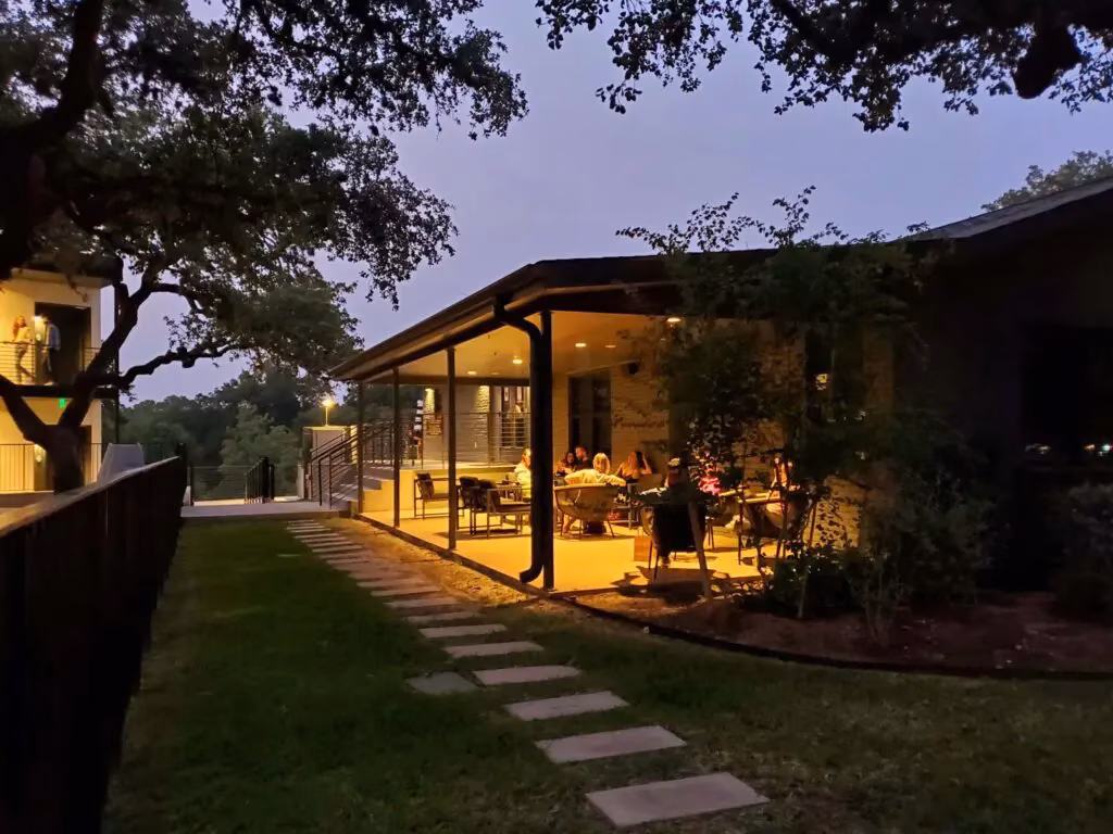 People dining on a brightly lit outdoor patio at dusk.