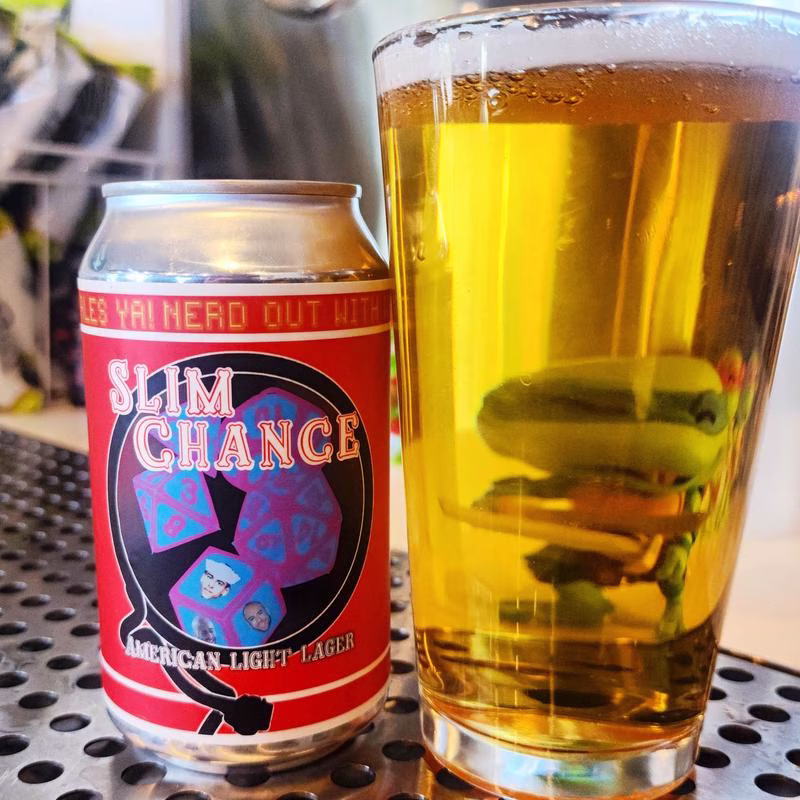 Red "Slim Chance" lager can and a glass with green figure.