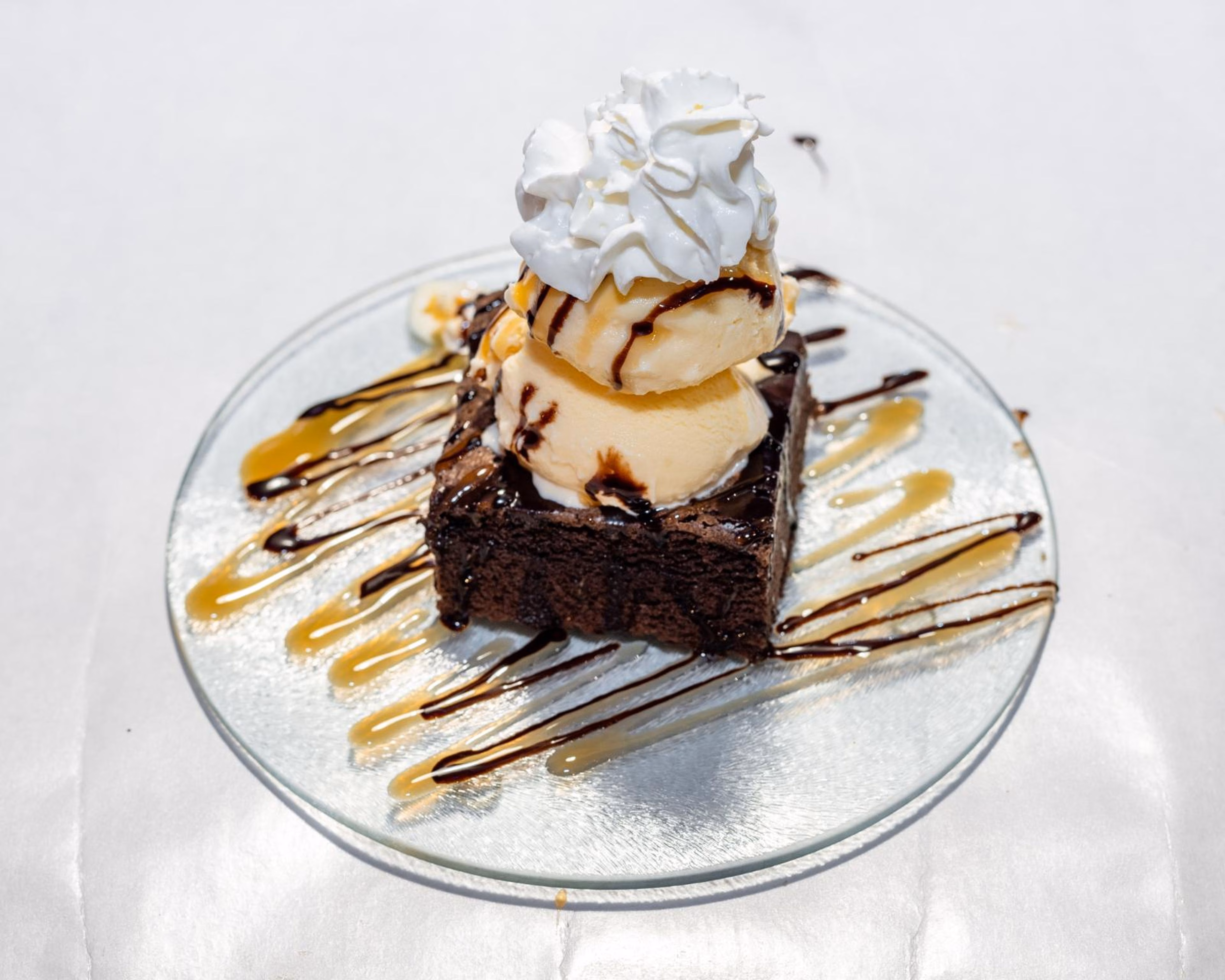 Brownie with vanilla ice cream, whipped cream, chocolate, and caramel drizzles.
