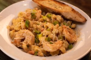Shrimp mac and cheese topped with green onions and a toasted baguette.