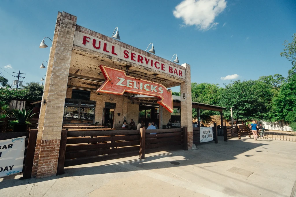 Zelick's Bar exterior, vintage neon sign, and outdoor diners.