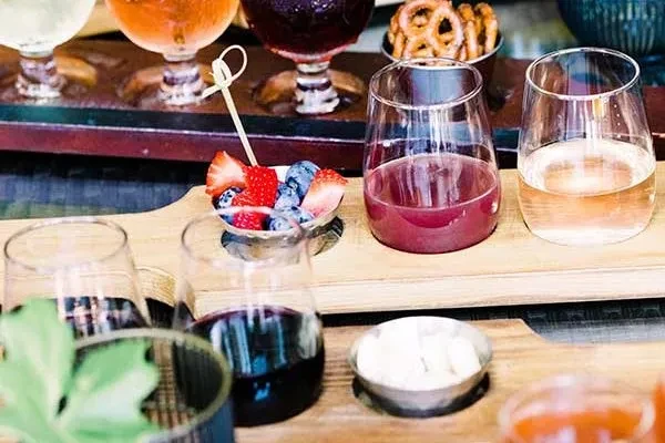 Cocktails, fruit skewers, and snacks served on wooden trays.
