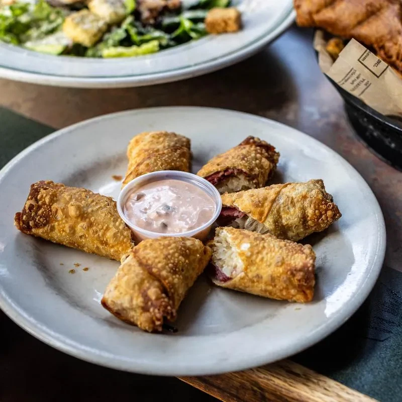 Six golden-fried rolls with corned beef, sauerkraut, and dipping sauce.