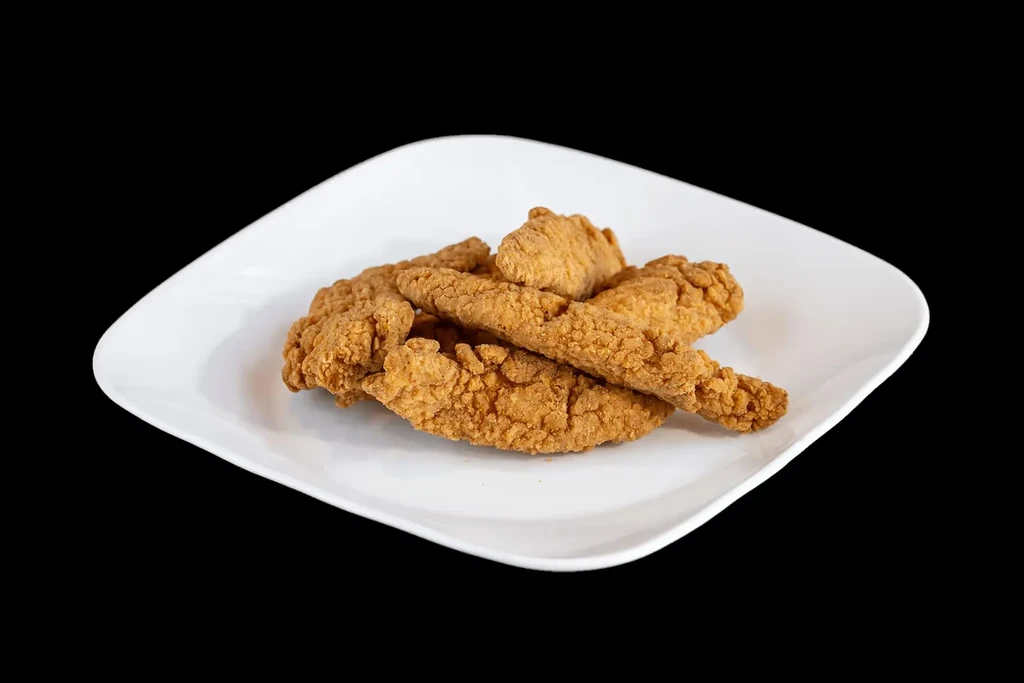 Close-up of crispy golden-brown fried chicken tenders on a modern white plate.