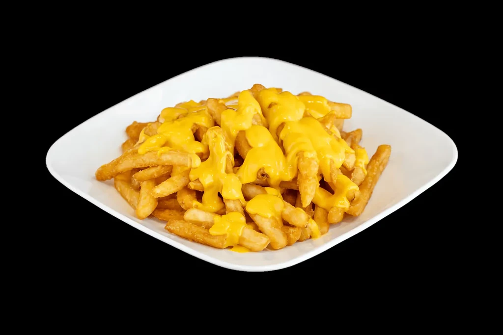 Crispy French fries coated in yellow cheese sauce on a white plate.