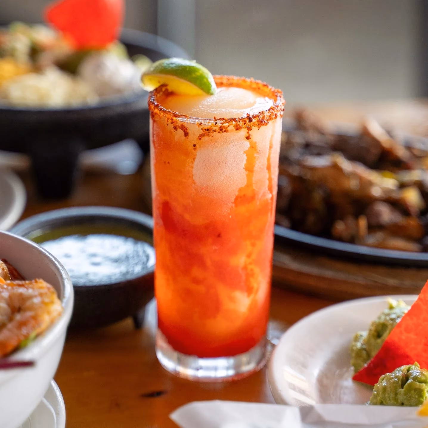 Red frozen drink with a chili-spiced rim and lime garnish.