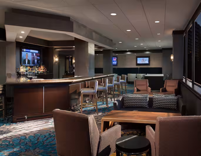 Spacious bar area with diverse seating and multiple televisions.