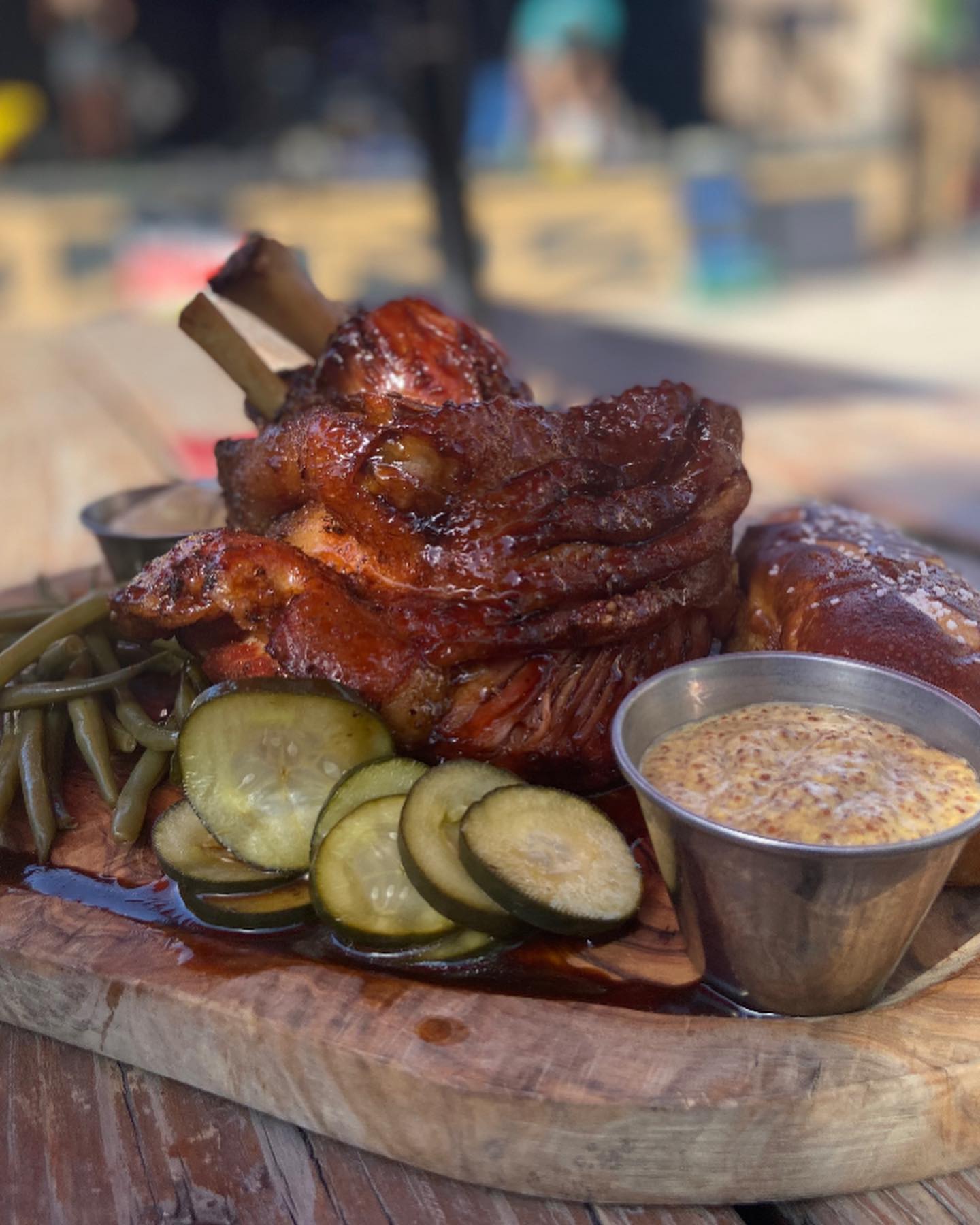 Roasted pork hock with green beans, pickles, mustard, and pretzel.