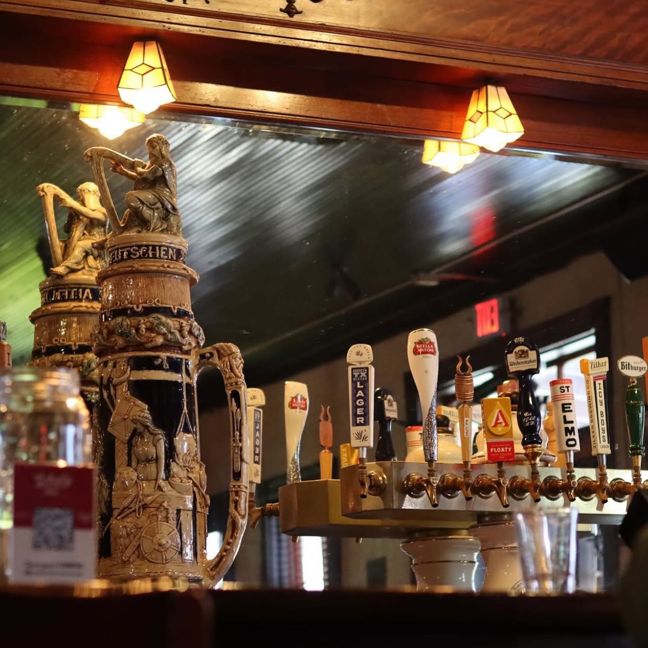 Ornate beer steins and a row of draft beer tap handles.