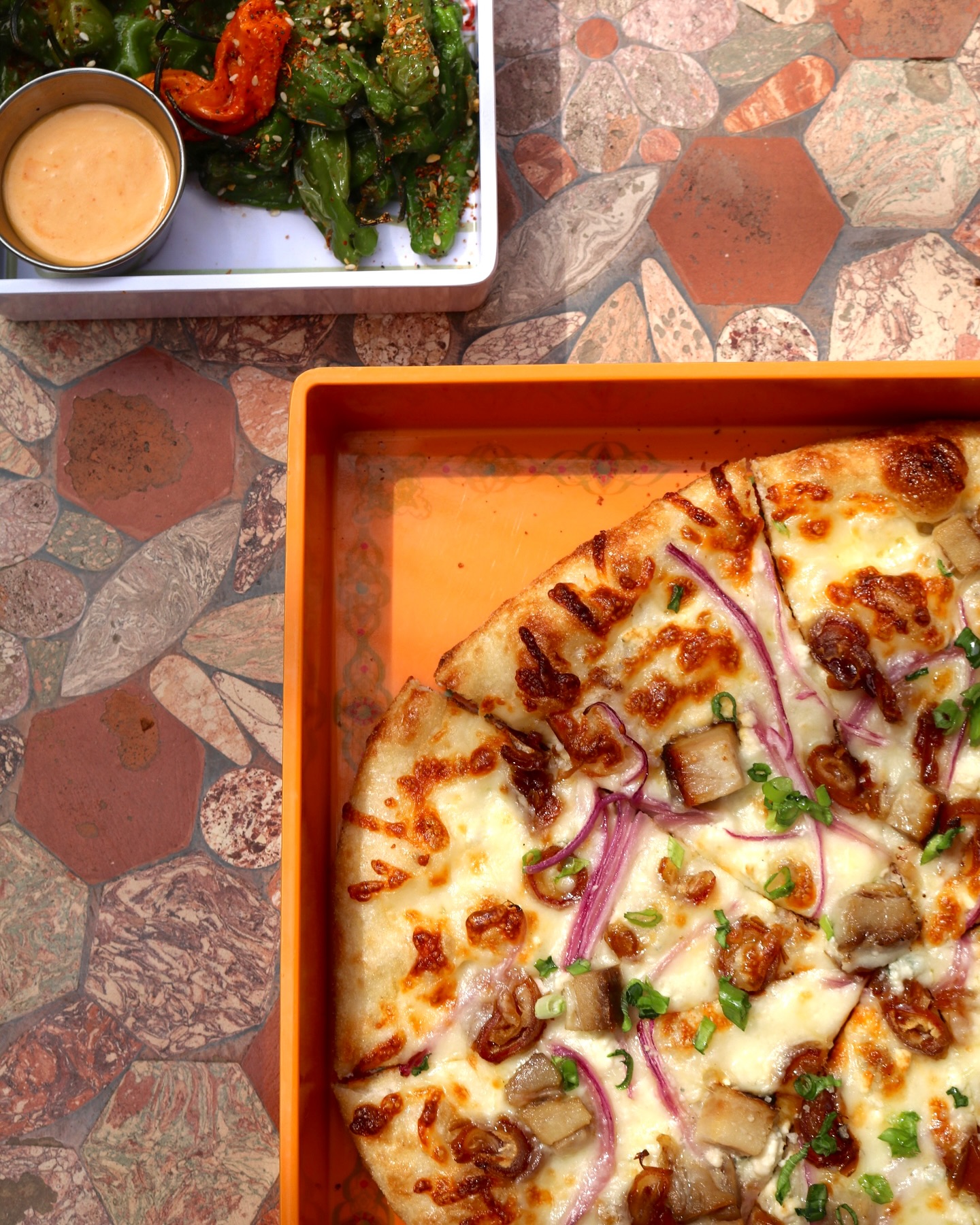 Pizza with meat and onions, roasted green peppers, and dipping sauce.