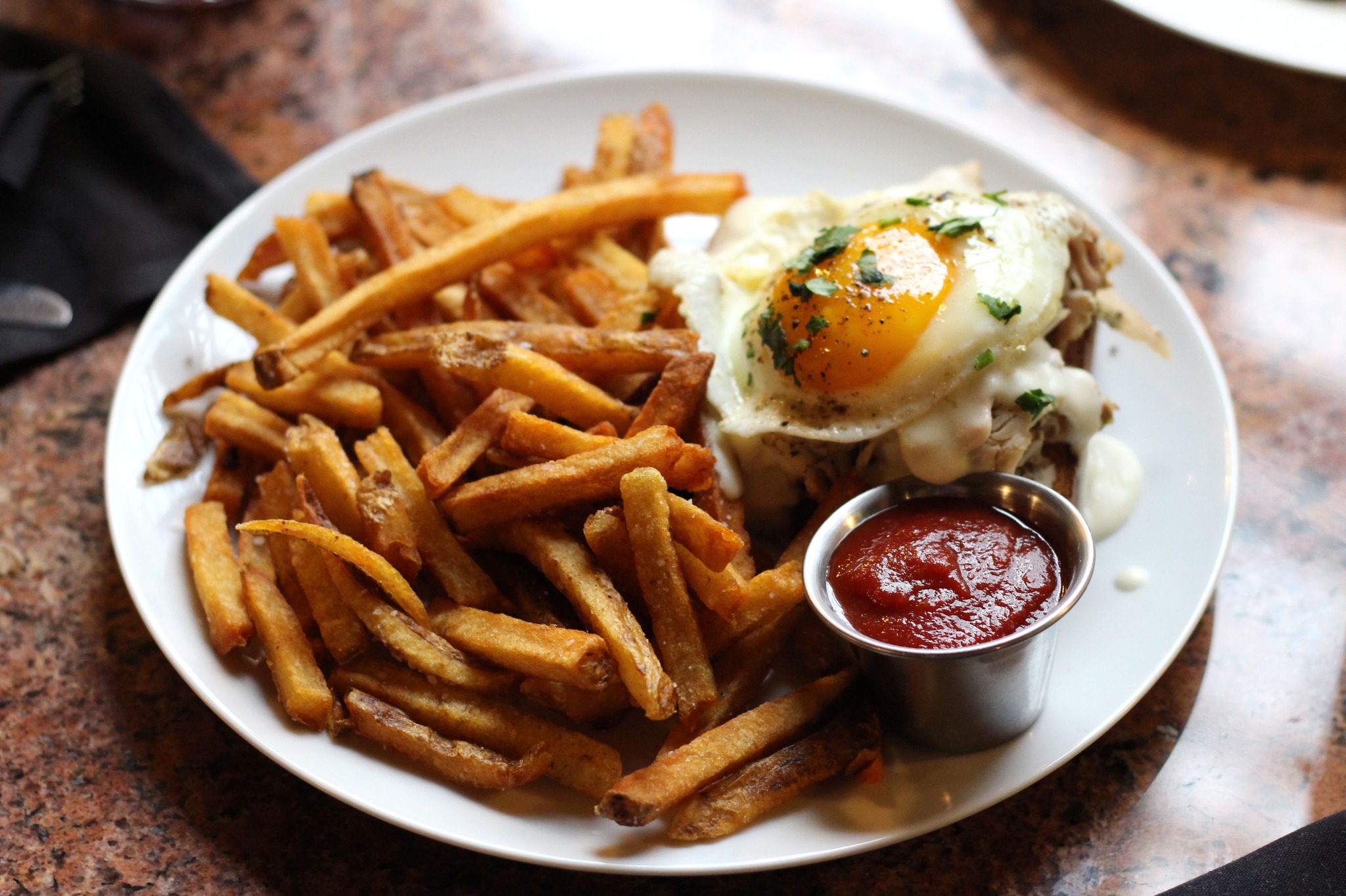Fries and an open-face sandwich with egg and ketchup.