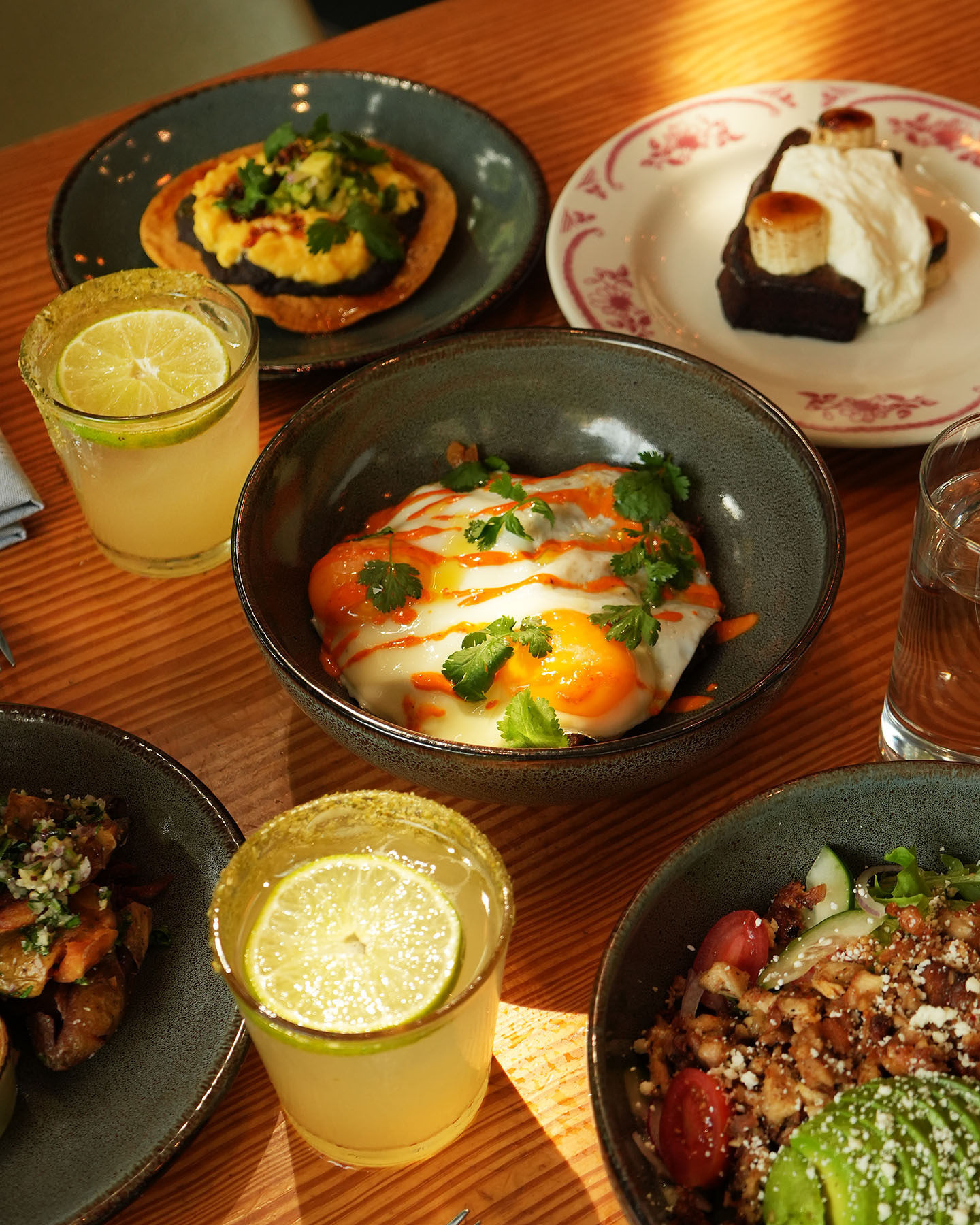 Table full of diverse breakfast and brunch dishes, drinks, and dessert.